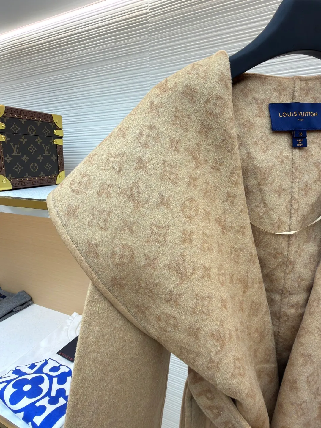 LOUIS VUITTON Wool lace-up wrap hooded coat (short style) ●Item number: 1682300-I45 ●Fabric: wool fabric ●Technology: jacquard production ●Color: khaki ●Version: loose fit ●Weight: about 1320 grams ●Size: 34-36-38-40 ●Description: This presbyopic wool coat is made of double-sided blended wool fabric imported from Italy. The main part is made of high-density matte black wool, which has been pre-shrunk and steam-set to ensure that the fabric is stiff and not easily deformed. The large lapel and belt areas use jacquard weaving technology to present the classic presbyopic pattern as a three-dimensional texture. The pattern is digitally positioned and plated to ensure that the texture is symmetrical and clear. The body of the garment is unlined and double-sided sewn to reduce the weight of the garment while improving skin-friendliness. The cuffs and hem are hand-stitched to reveal exquisite details. The waist is customized with a wide belt of the same fabric, with an adjustable buckle design with invisible stitching, allowing the silhouette to be freely adjusted; the neckline adopts a double-layer composite structure, combined with the fixation process of hand-made arch stitches, to make the large lapels more three-dimensional. Every splicing follows the precision sewing standard of 1cm/8 stitches, perfectly integrating craftsmanship and design aesthetics. The overall wiring is straight and delicate, the fabric is comfortable and soft, and the color is consistent without color difference. It can be matched with the same style to create a fashionable look and control various occasions. Customized accessories, complete with three standards, same style for men and women!